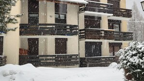 A multi-story building with a snow-covered roof and surrounding snow. - 6-PERSON APARTMENT PRALOGNAN LA VANOISE (Pralognan-la-Vanoise)