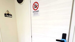 A closed door with a no-smoking sign, a clock, and a keycard reader. - HuB ROME Tourist Accommodation (Roma)