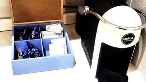 A coffee maker and a box of bottled water on a countertop. - HuB ROME Tourist Accommodation (Roma)