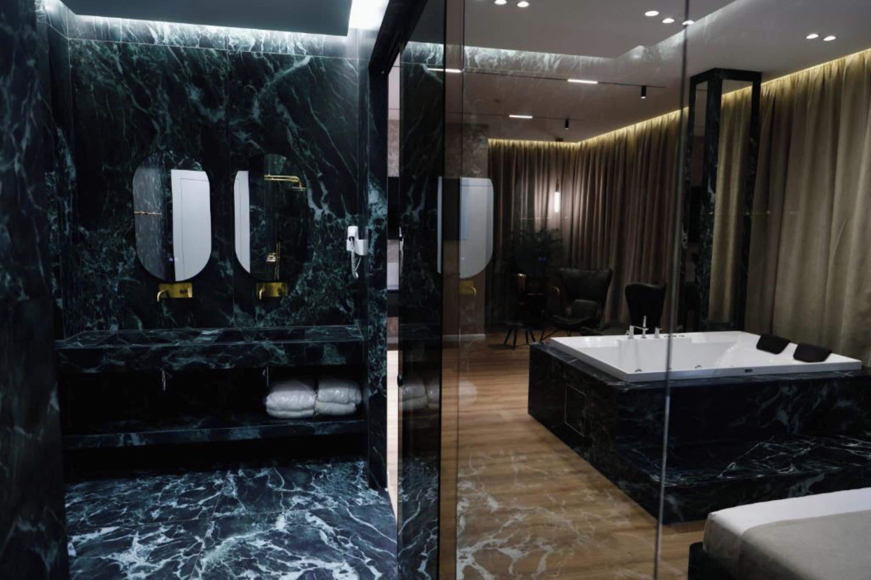 Un baño moderno con tocador de mármol, una bañera amplia y cabina de ducha independiente.