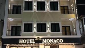A multi-story hotel with a prominent sign reading 'HOTEL MONACO.'