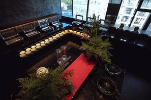 Un espace bar moderne doté d’un comptoir incurvé, de plusieurs distributeurs de boissons et d’une composition florale décorative.