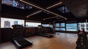 A gym with treadmills, a stationary bike, and a rowing machine. - Zhuhai Xumeishan Hotel  (Zhuhai)