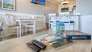 Een eethoek met een tafel, stoelen en een aan de muur bevestigde televisie.