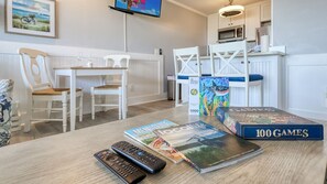 Een eethoek met een tafel, stoelen en een aan de muur bevestigde televisie.