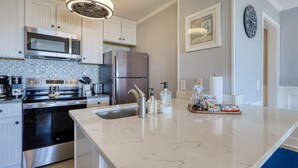 Een moderne keuken met roestvrijstalen apparatuur, een marmeren aanrechtblad en een spoelbak.