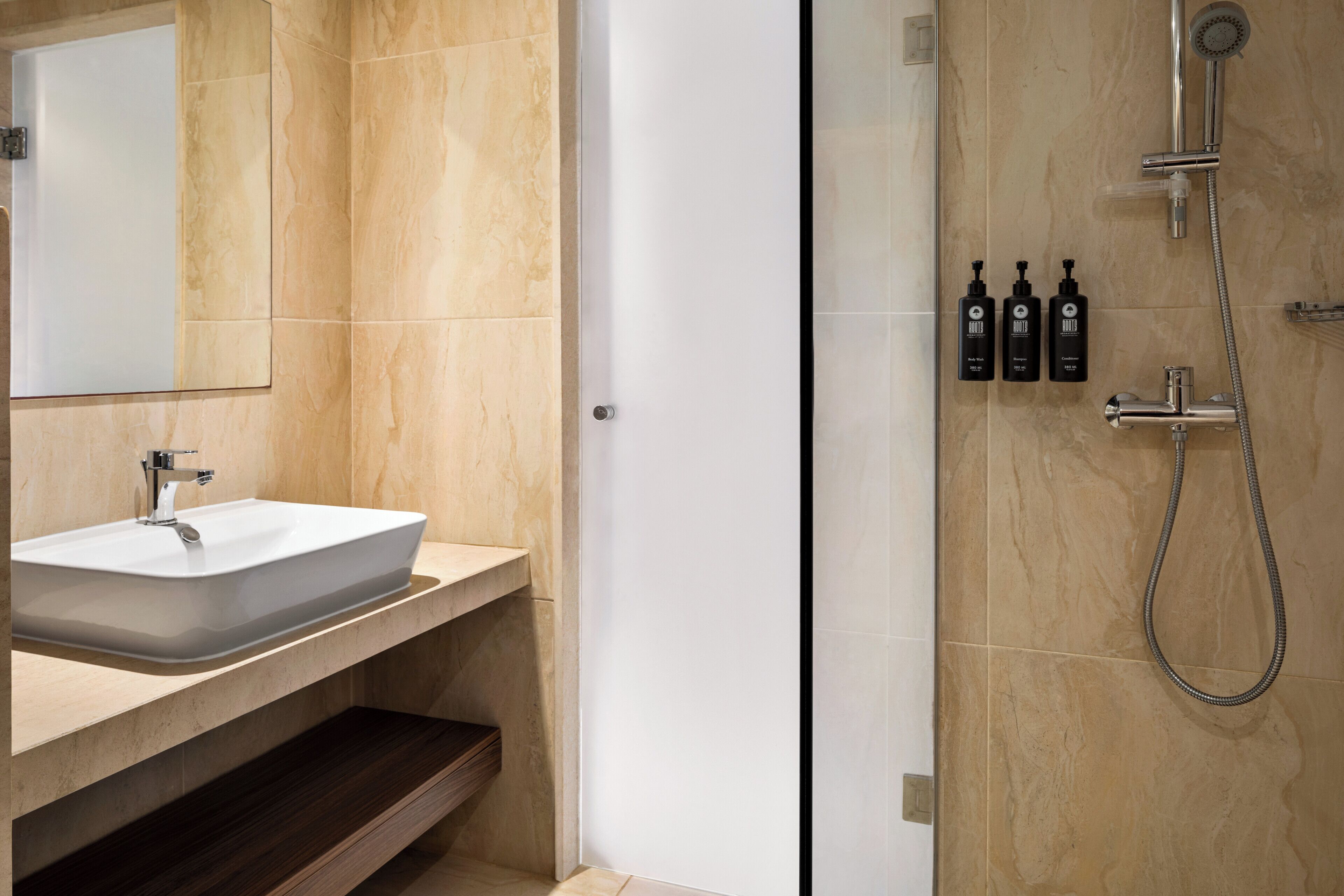 Een moderne badkamer met een grote wastafel, spiegel en douche.