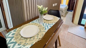 Una mesa de comedor con un mantel individual, dos platos y un florero con flores.