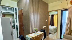 Un espacio habitable pequeño con kitchenette, comedor y sofá.