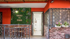 A hotel entrance with a green wall, a metal gate, and a staircase leading inside.