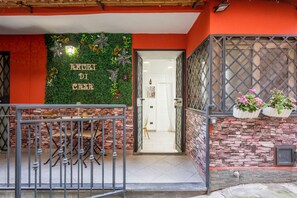 L’entrée d’un hôtel, avec un mur végétal, un portail en métal et un escalier menant à l’intérieur.