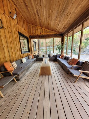 Une terrasse en bois avec un canapé, des chaises et une table basse.