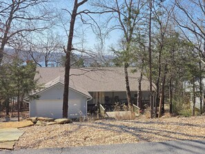 A house with a garage, surrounded by trees and a gravel driveway. - Wake and Lake- 6-bedroom house/ Lakefront on Beaver Lake (Garfield)