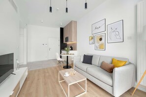 Ein modernes Wohnzimmer mit einer Couch, einem Couchtisch und einem Fernseher.
