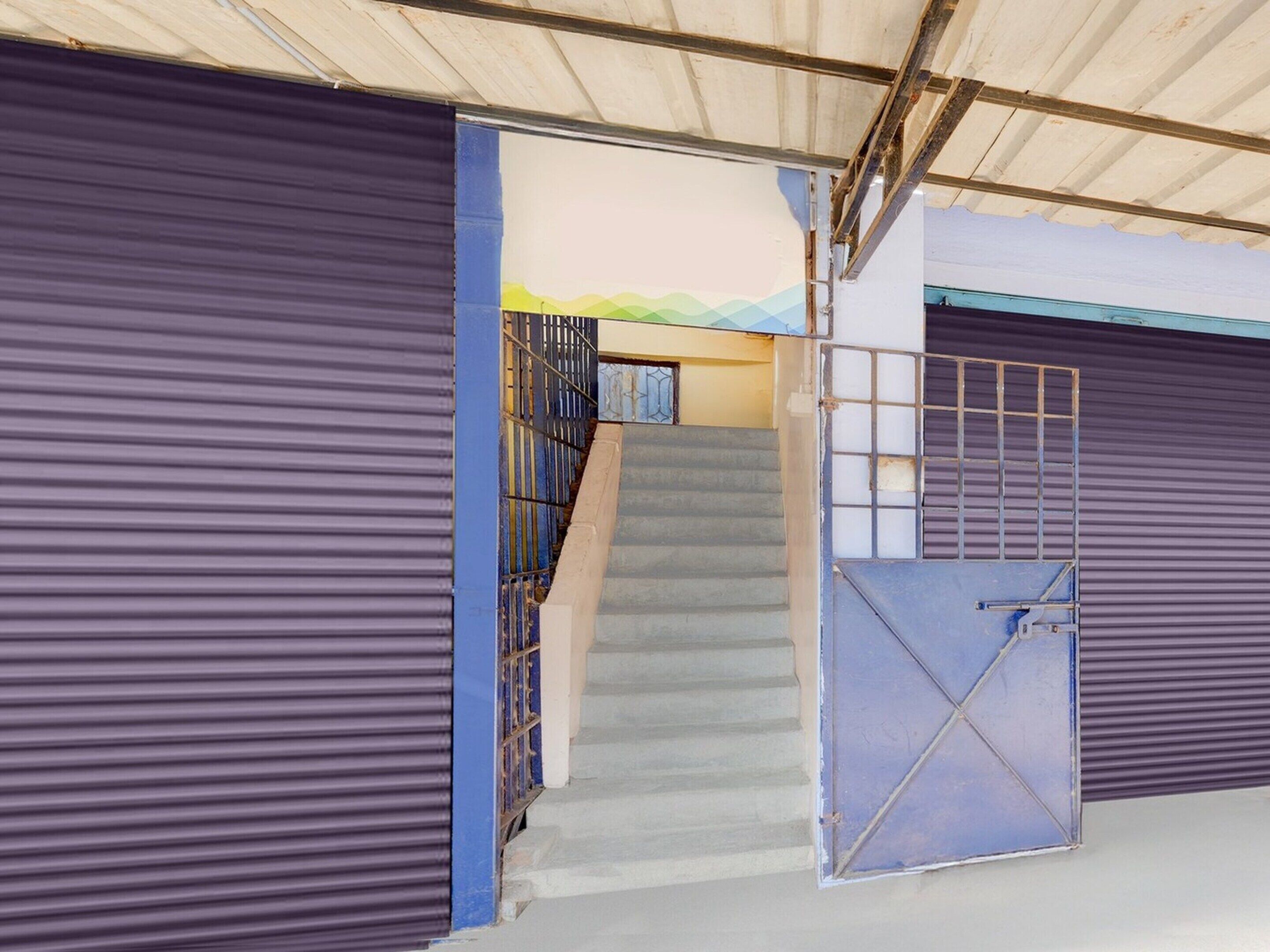 A staircase leading to a covered area with metal gates and a metal staircase railing.