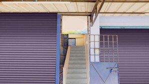 A set of closed metal shutters, a staircase, and a metal gate. - Deluxenimalan Residency (Chennai)