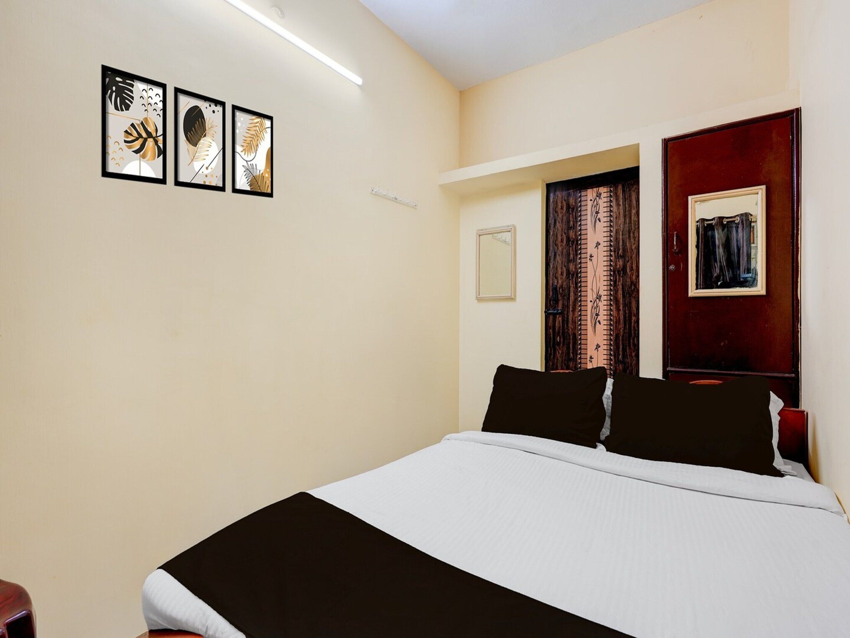 Una camera da letto con un letto, una porta e tre quadri appesi al muro.