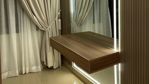 A modern room with a wooden vanity, a large mirror, and beige curtains. - Heritage Heaven (Karachi)