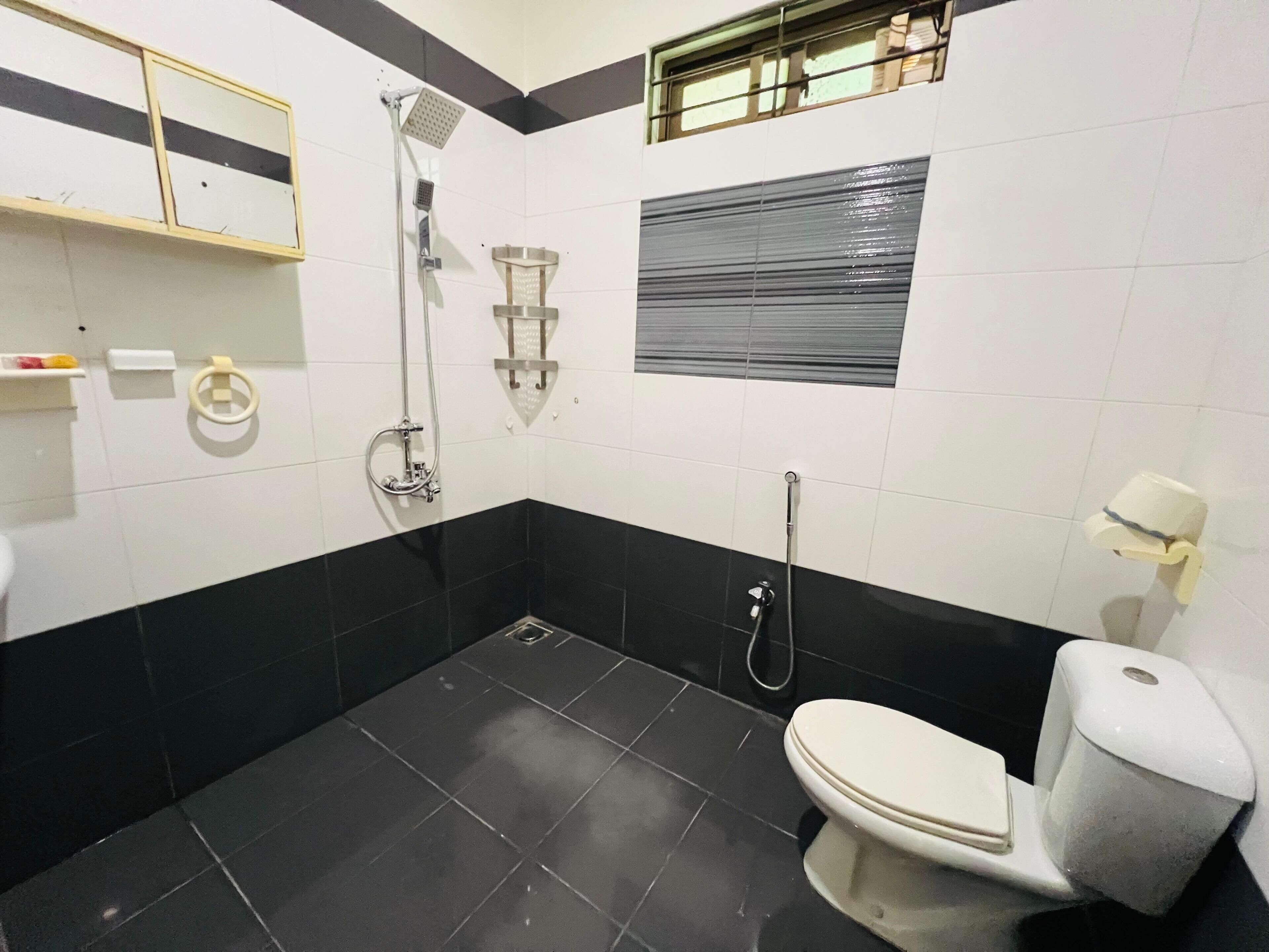 A bathroom with a toilet, a shower, and a sink.