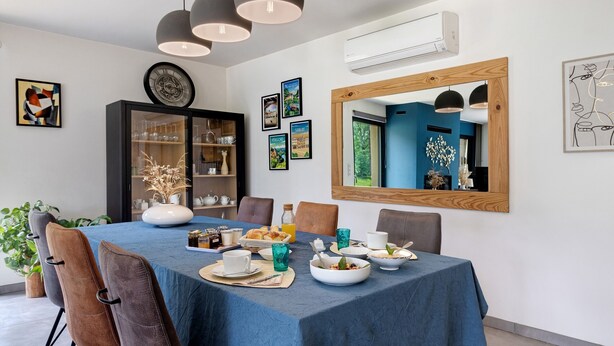 Ein Essbereich mit blauem Tischlein, Stühlen und einem Buffet.