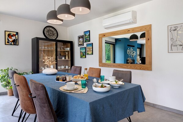 A dining area with a blue tablecloth, chairs, and a buffet setup.