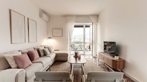 A modern living room with a sofa, coffee table, and TV stand. - Ruan Downtown (Como)