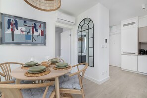 Ein Essbereich mit einem runden Tisch, Stühlen und einem Bild an der Wand.