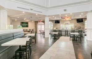 A spacious restaurant with high ceilings, multiple seating areas, and a bar counter. - Close to Disney: 3BR in Regal Palms Resort with Lazy River (Davenport)