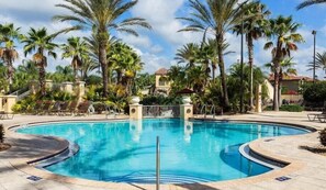 A swimming pool surrounded by palm trees and lounge chairs. - Close to Disney: 3BR in Regal Palms Resort with Lazy River (Davenport)