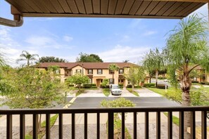 A residential building with a symmetrical facade, multiple windows, and a central driveway. - Close to Disney: 3BR in Regal Palms Resort with Lazy River (Davenport)