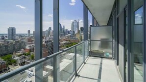 A high-rise building with a balcony overlooking a cityscape.