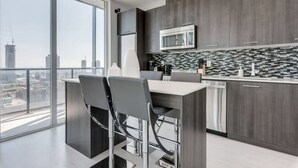 A modern kitchen with a large window, a microwave, and a bar area.