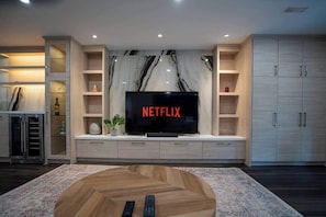 Relax in the spacious living room with comfortable seating and a 65" Smart TV. - Modern 3BR Basement Retreat w/ Workspace & Parking (Toronto)
