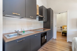 Une cuisine moderne équipée d’un évier, d’un four et de placards.