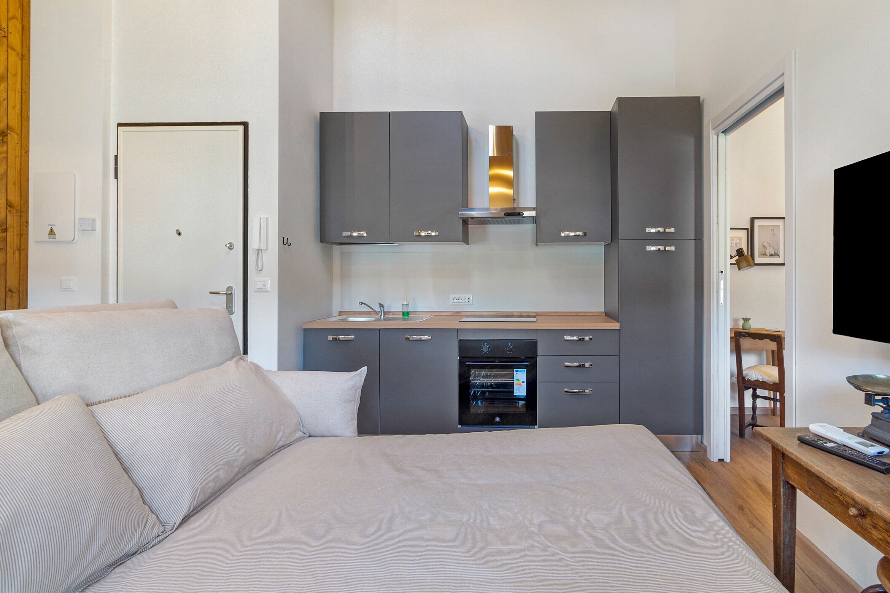Une chambre à coucher comprenant un lit, une table de chevet, une commode et un four encastré.