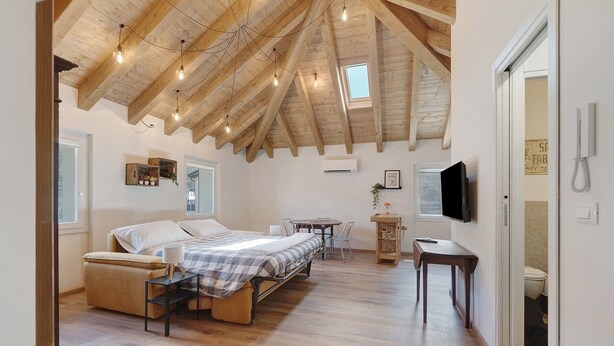 Une chambre à coucher avec un lit, une table de chevet et un téléviseur.