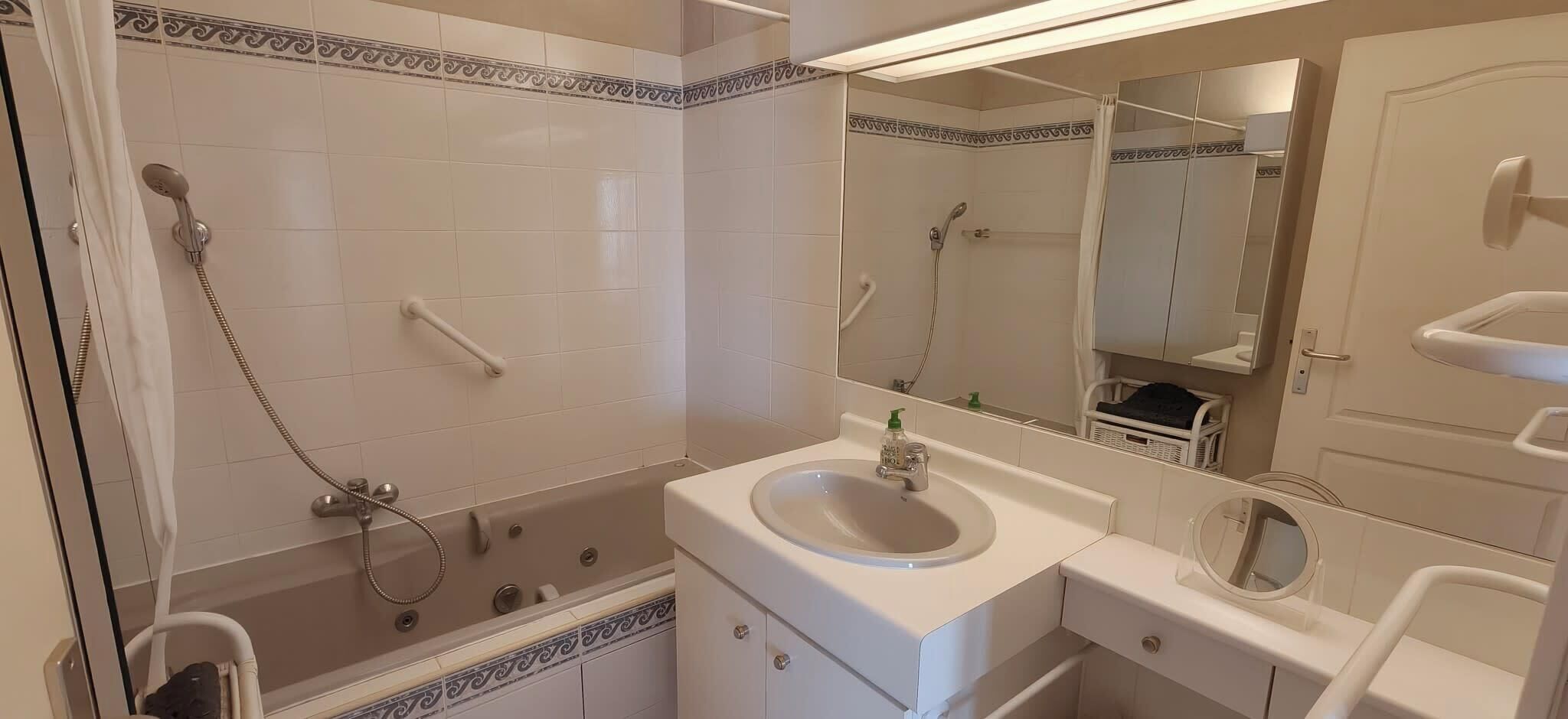 Ein Badezimmer mit Badewanne, Waschbecken, Spiegel und Dusche.