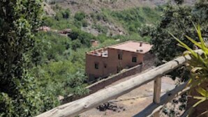 Paisaje montañoso con un edificio en primer plano.