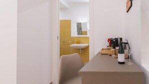 A modern bathroom with a sink, mirror, and a chair. - Light View (Taormina)