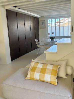 A modern living room with a sofa, a dining table with chairs, a dark wooden wardrobe, and a window with a view. - Charming Arcachonnaise near beaches and port for 6 people (Arcachon)