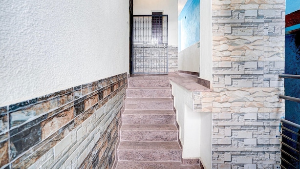 A staircase with stone steps and a stone wall on the right. - Suite Gm Comforts (Bengaluru)