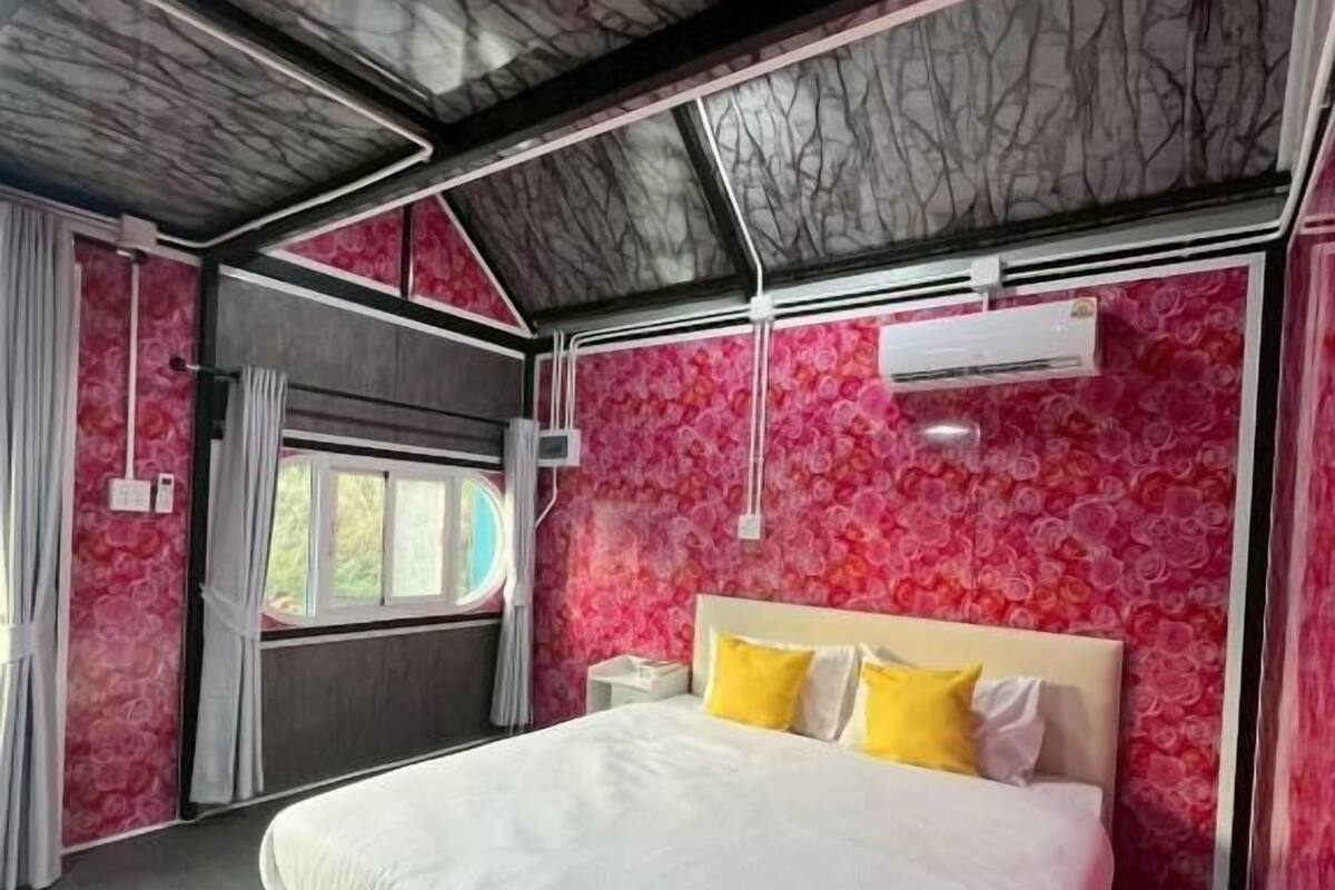 A bedroom with a large bed, a window, and a ceiling with a marble-like pattern.