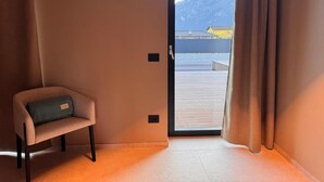A room with a view of a dock and mountains, a chair, and a door. - Vinea Rural Resort (Arco)