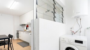 Cocina compacta con comedor, lavadora y calentador de agua.