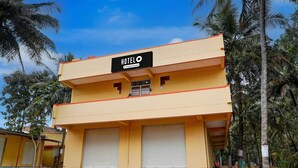 A two-story building with a sign reading 'HOTEL O' and a company-serviced logo. - Hotel O Bidadi Railway Junction (Ramanagara)