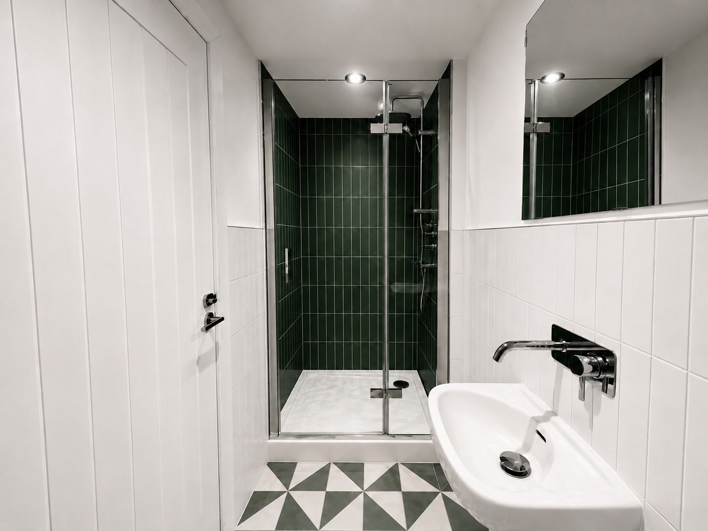A modern bathroom with a shower, a sink, and a tiled floor.