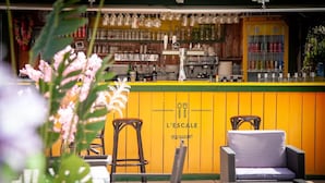 An outdoor seating area with a bar, chairs, and a sign reading 'L'ESCALÉ RESTAURANT'. - Mobil-home tout confort Camping de l’Escale C43 terrasse, piscine & plages (Agde)