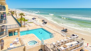 Ein Poolbereich mit Blick auf Strand und Meer.
