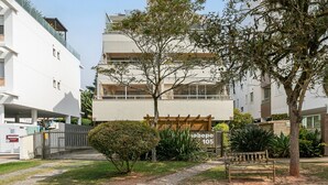 Un immeuble résidentiel doté d’une entrée sécurisée par un portail, d’une pergola et d’un banc dans la cour.