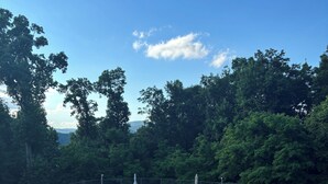A swimming pool with lounge chairs and a stone wall. - Bent Tree Family 2BR - Hot Tub, Mountain View Deck, Pool, Golf, Lake & Fish (Jasper)